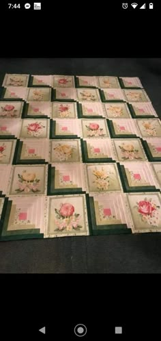 a quilted table topper with flowers on it and green border around the edges