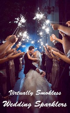 a bride and groom kissing while surrounded by sparklers