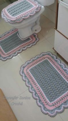 two bathroom rugs on the floor next to a toilet