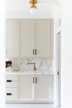 a white kitchen with marble counter tops and cabinets on instagramture for an appliance