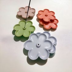 three different colored flower shaped buttons on a white surface with one button facing the camera