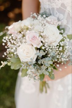 a bridal holding a bouquet of white and pink flowers