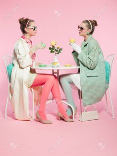 two women sitting at a table having tea