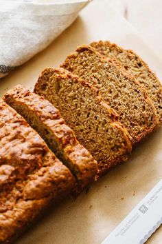 sliced loaf of banana bread sitting on top of a cutting board next to a knife