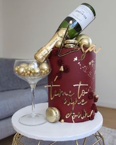 a red cake with gold decorations and a bottle of wine