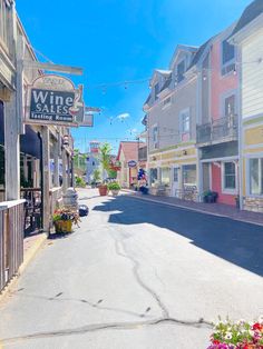 an empty street with shops and flowers in the foreground, on a sunny day