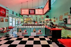 the interior of a diner with checkered flooring and neon signs