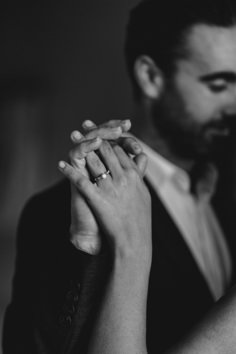 black and white photograph of a man and woman holding each other's hands together