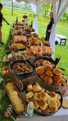 an outdoor buffet is set up on the grass