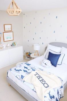 a bedroom with blue and white decor on the walls, bedding and nightstands