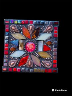 a decorative glass tile with colorful designs on it