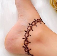 a woman's foot with a henna tattoo on it