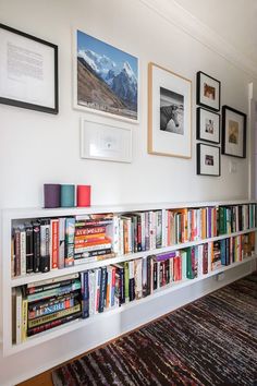 a bookshelf filled with lots of books on top of a carpeted floor