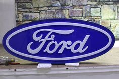 a blue ford sign sitting on top of a window sill next to a brick wall