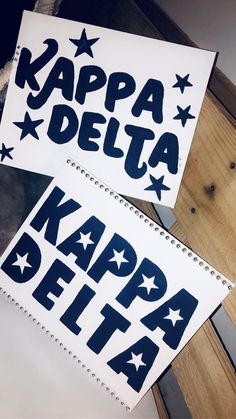 two notebooks with the words kappa delta written in blue on them