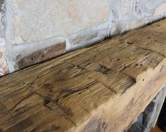 a wooden bench sitting next to a brick wall in front of a stone fireplace mantel