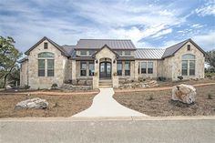 a large house with stone and metal roofing