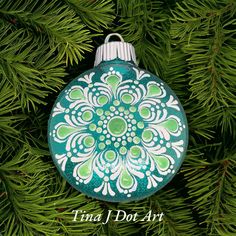 a green and white ornament hanging from a tree