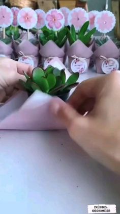 someone is placing flowers in small vases on the table