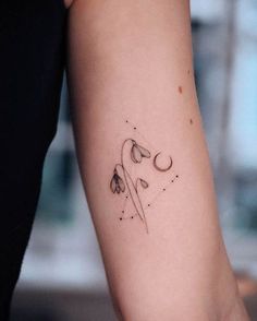 a woman's arm with a tattoo on it that has flowers in the middle