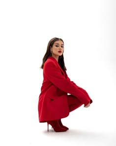 a woman in a red coat is posing for the camera with her legs spread out