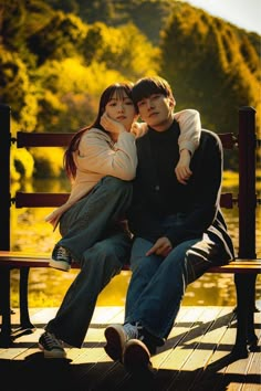 a man and woman sitting on a bench next to each other with their arms around one another