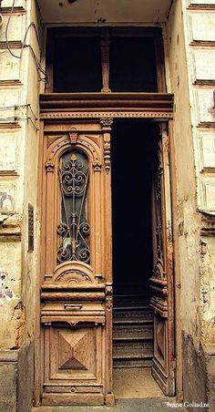 an old wooden door with ornate carvings on the front and side of it, open