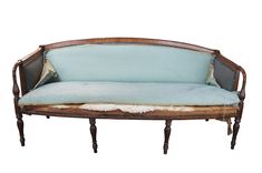 an old wooden couch with blue upholstered fabric on the back and arms,