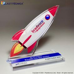 a plastic model of a red and white rocket ship on a clear acrylic stand