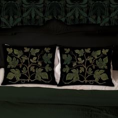 two black pillows with green leaves on them