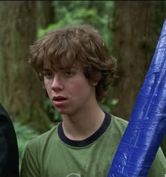 a young man holding a blue plastic bat