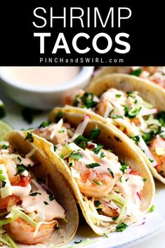 shrimp tacos on a plate with sauce and cilantro