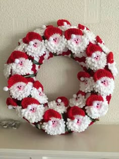 a crocheted christmas wreath with santas on it