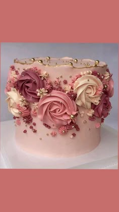 a close up of a cake with pink frosting and flowers on it's side