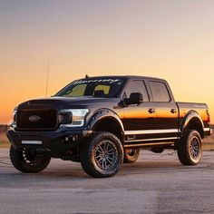 a large black truck parked on top of a tarmac