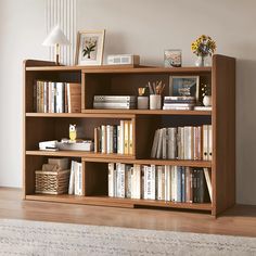 a bookshelf filled with lots of books on top of a hard wood floor