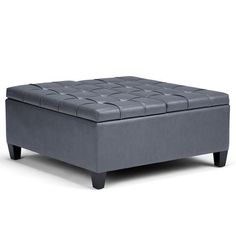 a gray ottoman sitting on top of a white floor