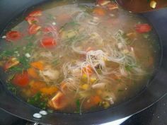 a pan filled with soup sitting on top of a stove