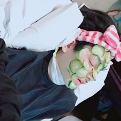 a woman with cucumbers on her face laying down