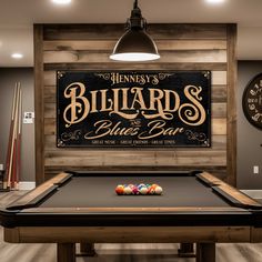 billiards and blue bar sign mounted on the wall above a pool table in a game room