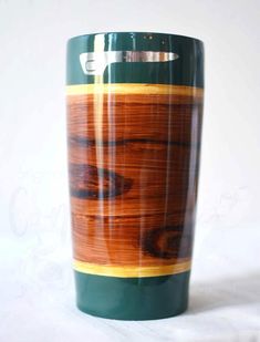 a green and brown cup sitting on top of a white table