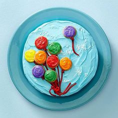 a blue plate topped with a cake covered in frosting and colorful icing flowers