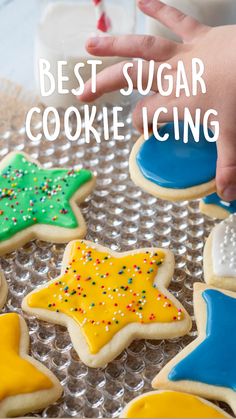 a child reaching for some decorated cookies on a tray