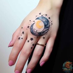 a woman's hand with a crescent and stars tattoo on it