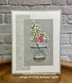 a close up of a card with flowers in a bucket on it and the words flower market