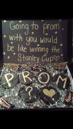 a box filled with lots of badges and some writing on the front, along with a sign that says going to prom with you would be like winning the stanley cup?