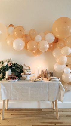 a table topped with lots of balloons and plates