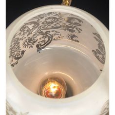 the inside of a white vase with a light in it