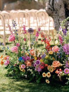 an arrangement of colorful flowers in front of rows of chairs