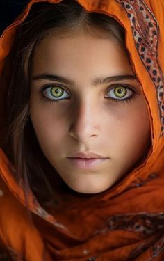 a woman with green eyes wearing an orange scarf